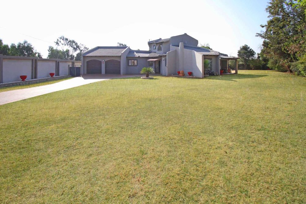Front View of the Property with Automated Double Timber Garage Doors, A Paved Driveway and the Expansive Garden Terrace.  The Newly Built Fence is particularly attractive at night with down lights that lit-up the Driveway and Garden Terrace.  
