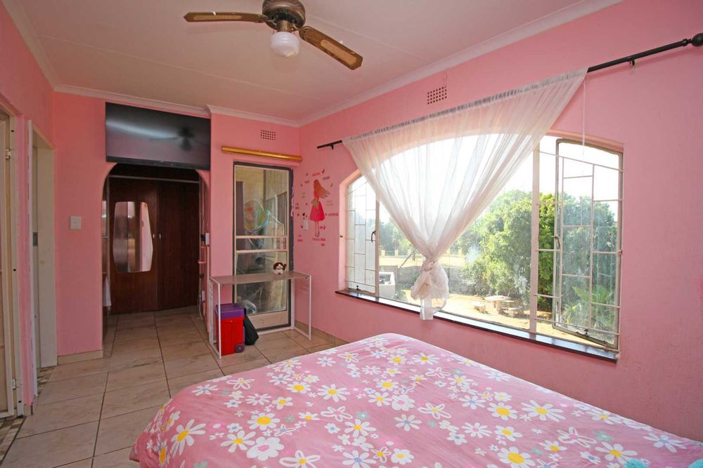 Bedroom 1 : Main Ensuite Bedroom with walk-in Dressing Room with His& Hers Built-In Cupboards and a Balcony that overlooks the expansive Garden Terrace, the Swimming Pool and the Entertainment Area