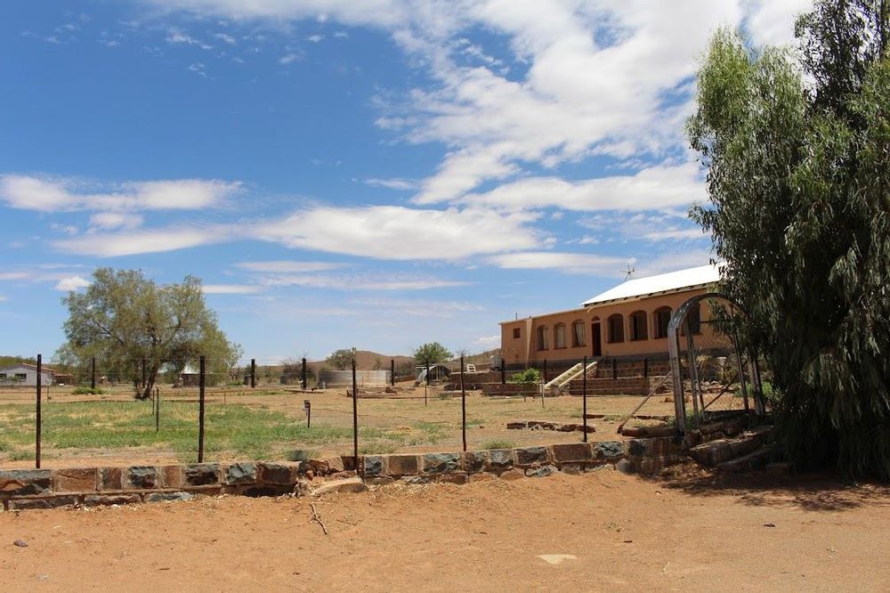 Side view of the main house and fencing as well as a dam in the background
