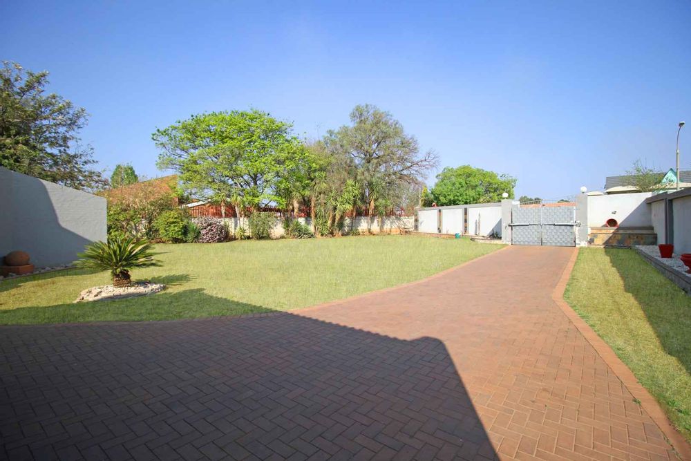 View of the Property from the Automated Double Timber Garage Doors. Paved Driveway and the expansive Front Garden Terrace with the newly built Exterior Fence and the automated Front Gate.  The Newly Built Fence is particularly attractive at night with down lights that lit-up the Driveway and Garden Terrace.