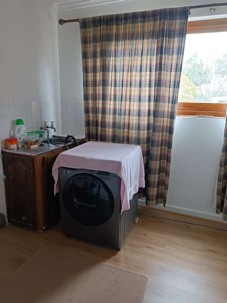 Room with space for washing machine and extra basin leading from dining room