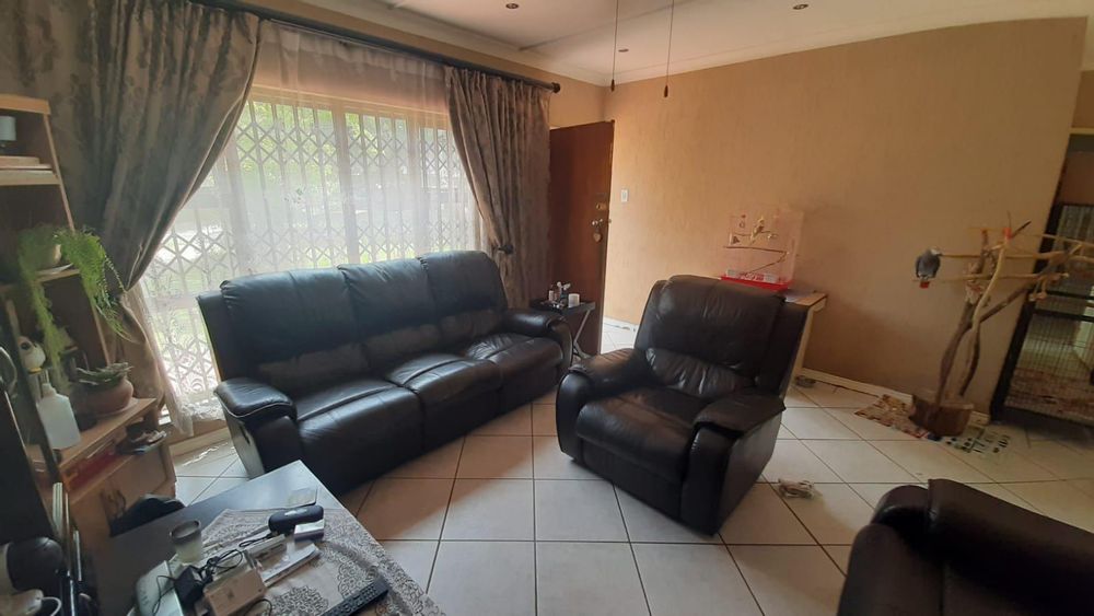 Open plan tiled lounge with a large sunny window