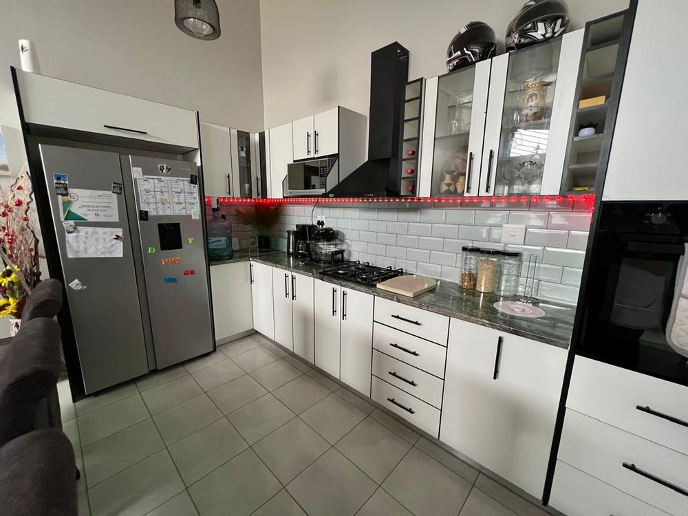 Open-plan kitchen, lounge and dining room. Built-in cupboards, stove and oven