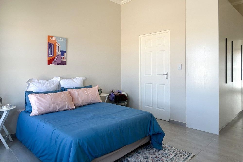 A spacious main bedroom with built-in cupboards and ensuite bathroom.