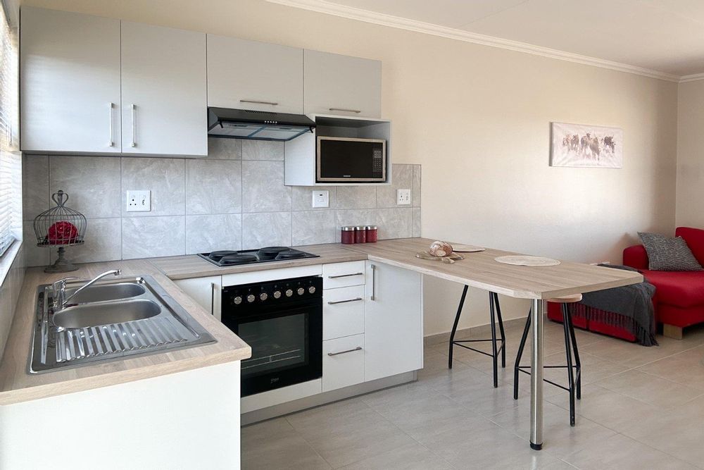 Kitchen with built-in cupboards + oven and sit-down countertop.