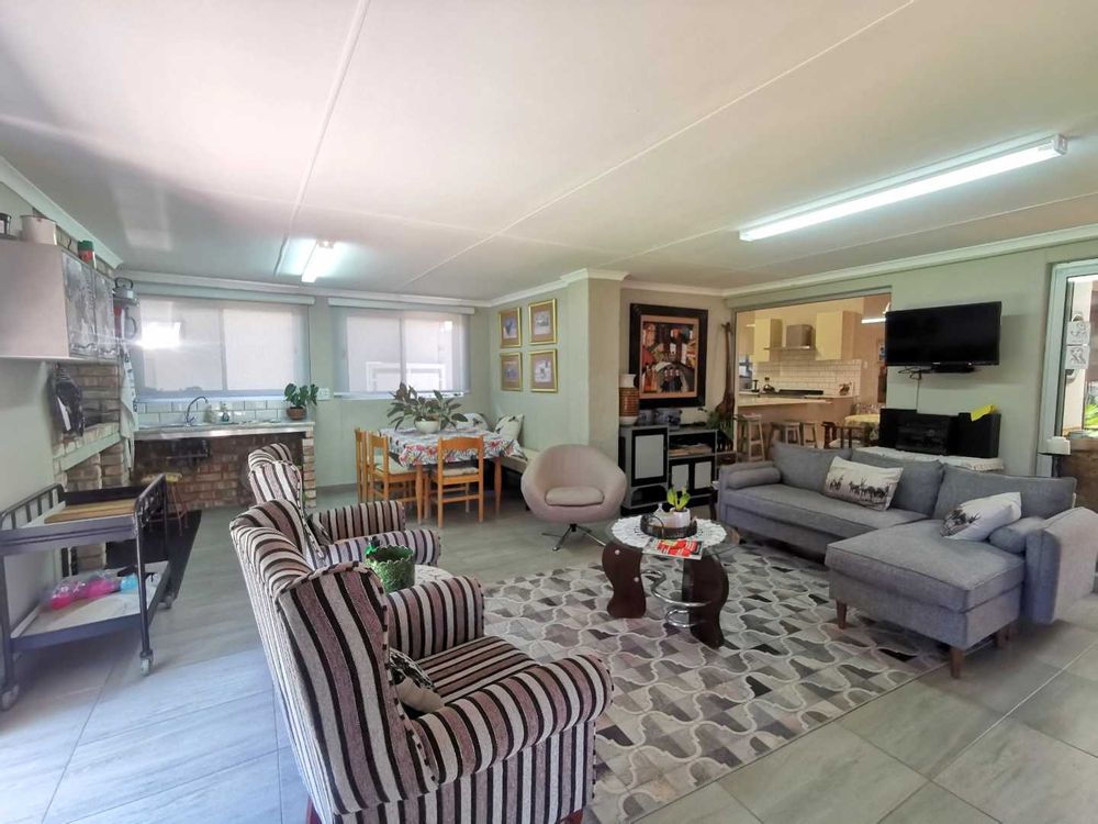 NEXT TO THE OPEN-PLAN KITCHEN WITH LOUNGE IS THIS INDOOR ENTERTAINMENT/FAMILY  ROOM WITH BUILT-IN BRAAI 