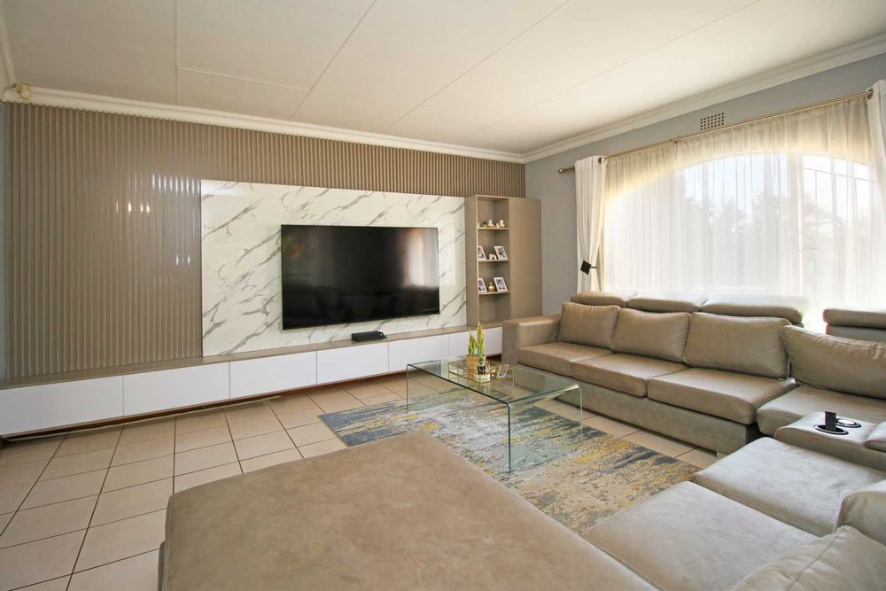 A modern and luxurious Wall Mounted Floating TV Unit is a very attractive designer concept and entertainment system saving floor space and creating a modern aesthetic in this Living Room. This is the Living Room everybody aspires for that can show-off your 8-seater lounge suite with it's double daybed and still offer more room for additional lounge chairs from the adjacent formal lounge.  This property will awaken the host in you because it's high time you start to live life to it fullest!  Here you can easily make all your dreams come true and invite everybody in your circle of loved ones!  The Living/TV Room has beautiful and modern finishes such as cornices, tiles and all the space your family has always wished for! 