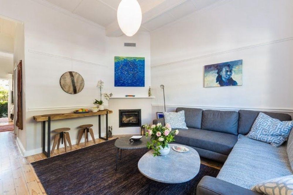 Living room with wood-burning fireplace and high ceilings 