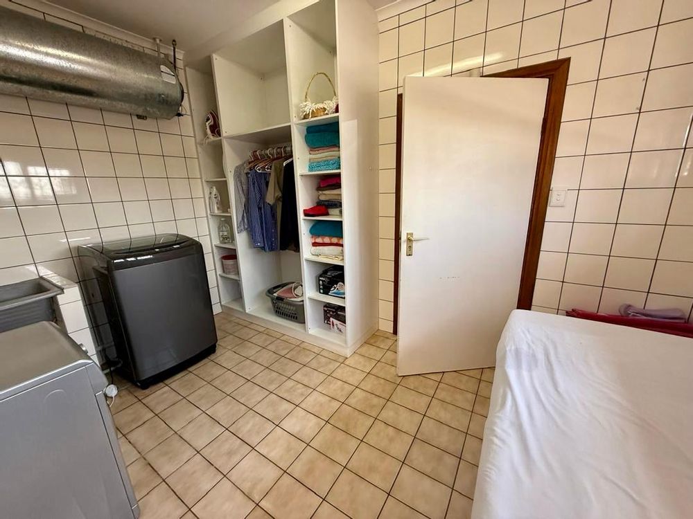 Laundry room behind walk-in closet