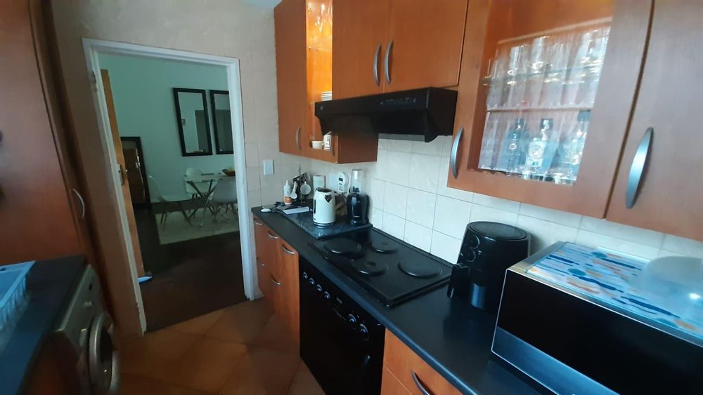 Modern cupboards with melamine countertops and stove with extractor fan