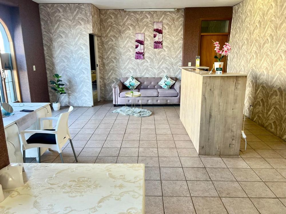 Reception area with couch, desk, and treatment desks for nail treatments