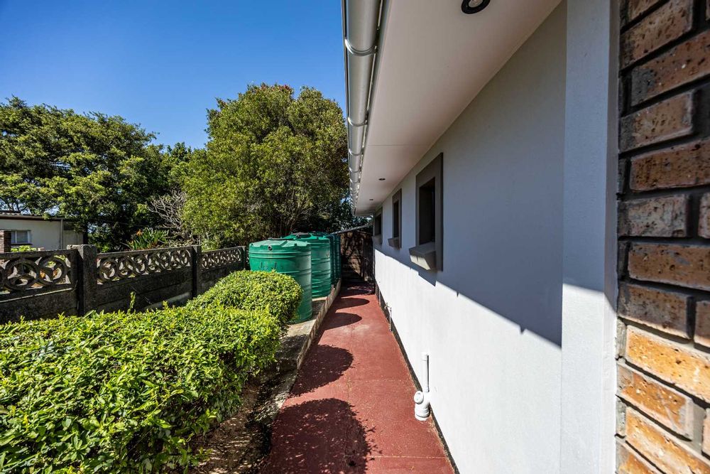 Side of home containing rainwater tanks and pump system