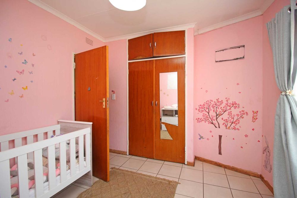 Bedroom 3 : The Nursery with Baby Cot, Baby Compactum Unit and Wing Back Armchair and matching Ottoman, with Built-In Cupboards and Tiled Floors