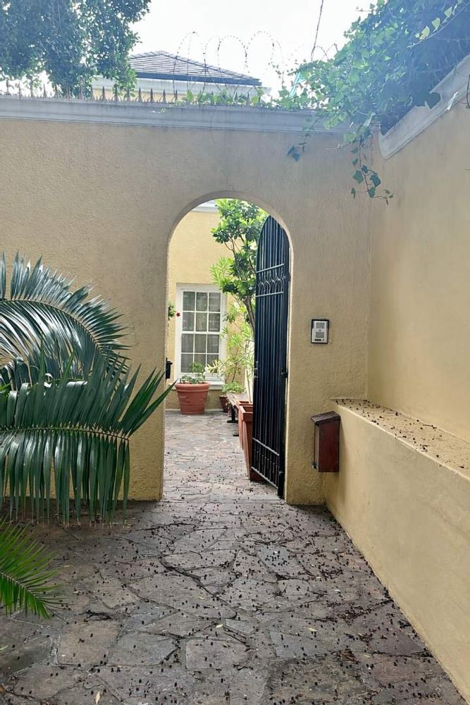 Charming courtyard entrance with archway and plants.