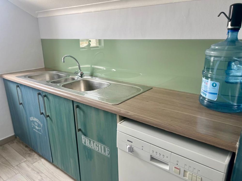 Scullery with sink and countertop as well as space for dish washer