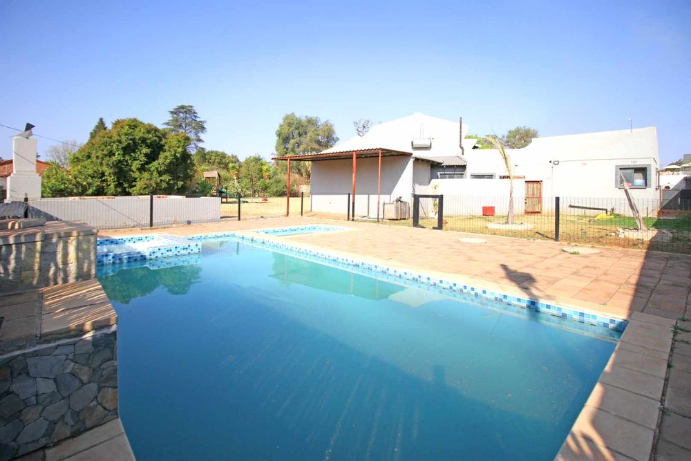 Swimming Pool with Integrated Jacuzzi and Kiddies Pool enclosed with Clearview Pool Fence and Self-Closing Gate as an essential safety feature ensuring the gate latches after every use to prevent unsupervised access to the pool by children or pets, as required by safety regulations.