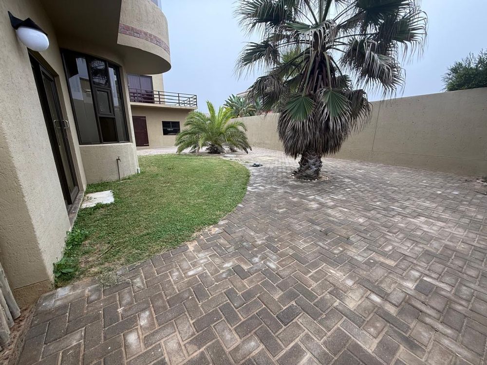 Front yard view. Carport spaces entering through a side gate