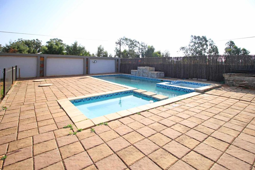 Swimming Pool with Integrated Jacuzzi and Kiddies Pool enclosed with Clearview Pool Fence and Self-Closing Gate as an essential safety feature ensuring the gate latches after every use to prevent unsupervised access to the pool by children or pets, as required by safety regulations.