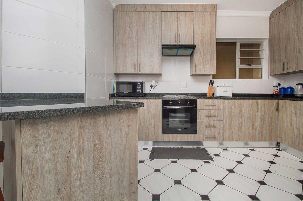 Newly renovated kitchen with neutral wrap doors and granite