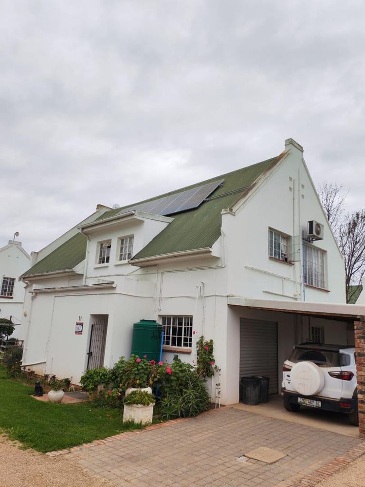 back door with security gate, garage door and under cover parking all visible in this photo
