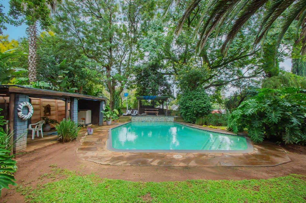 Exquisite garden and sparkling pool with covered resting spots