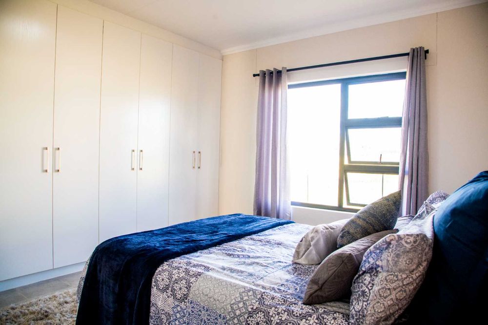 Spacious main bedroom with built-in cupboards and ensuite bathroom.