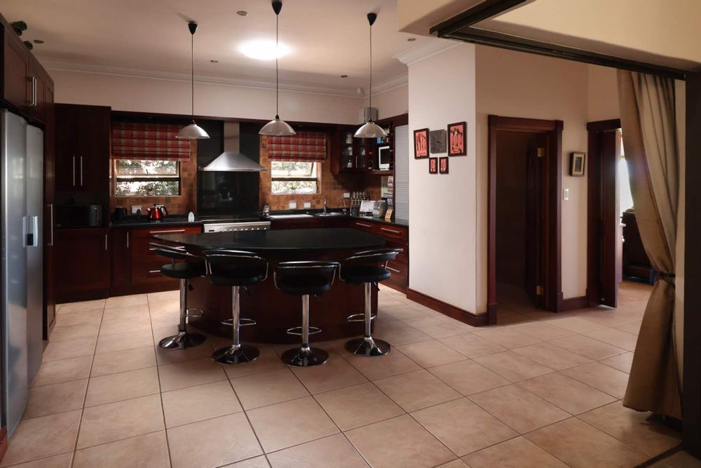 Kitchen as seen from dining area, with passage to powder room and separate family room