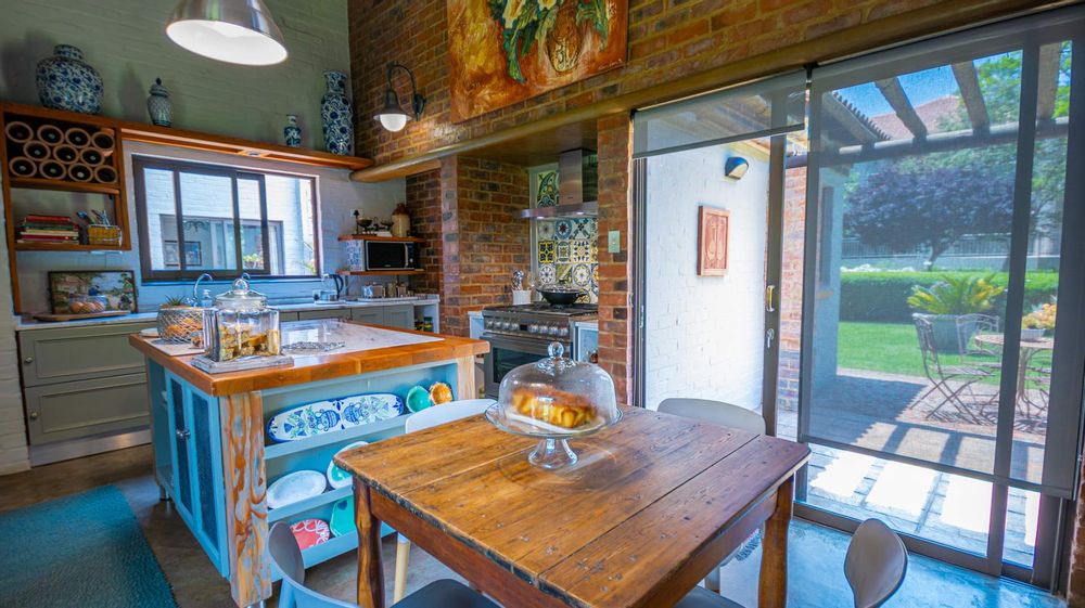 Kitchen with outside patio onto large green treed area.