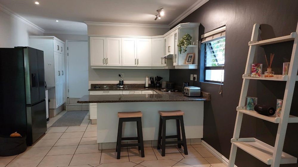 Kitchen and breakfast bar and hidden scullery with direct access to the garage