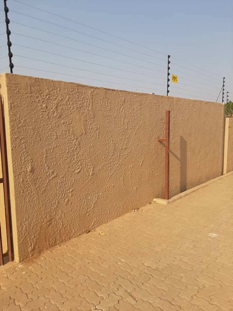 Boundary wall with electric fencing.