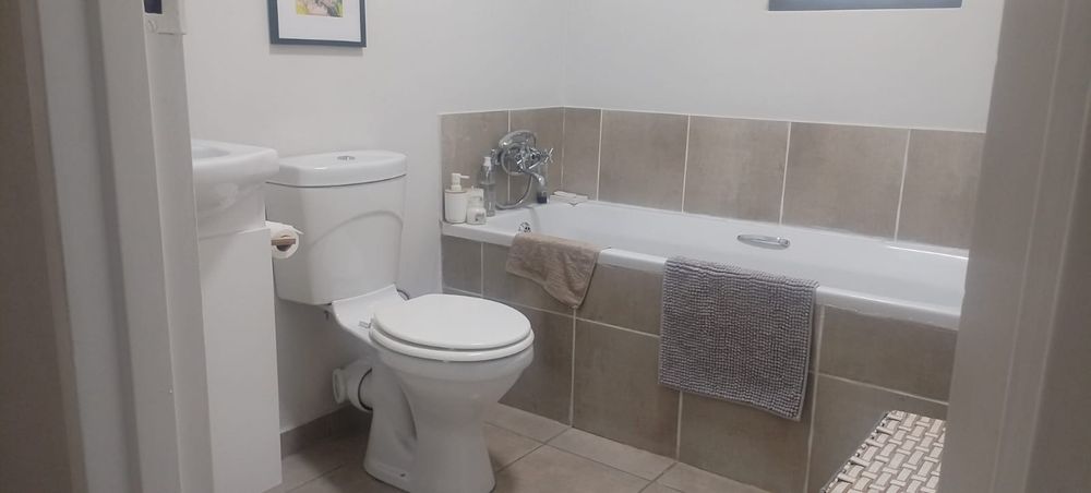 Second bathroom with bath, toilet and basin in a vanity cupboard