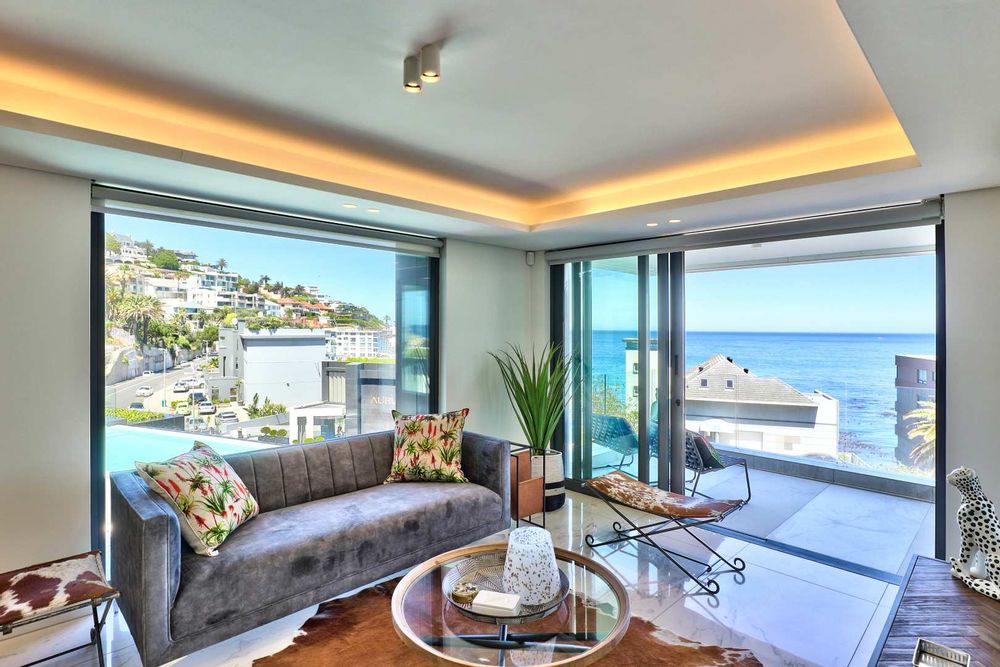 spacious luxurious open plan living space opens onto terrace with Atlantic Ocean and pool views