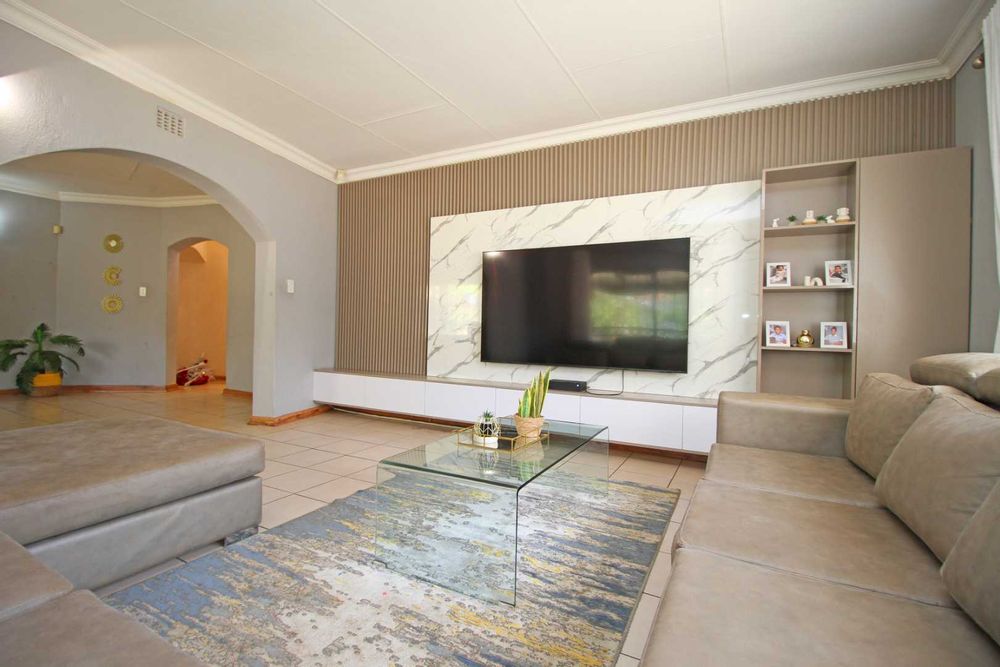 A modern and luxurious Wall Mounted Floating TV Unit is a very attractive designer concept and entertainment system saving floor space and creating a modern aesthetic in this Living Room. This is the Living Room everybody aspires for that can show-off your 8-seater lounge suite with it's double daybed and still offer more room for additional lounge chairs from the adjacent formal lounge.  This property will awaken the host in you because it's high time you start to live life to it fullest!  Here you can easily make all your dreams come true and invite everybody in your circle of loved ones!  The Living/TV Room has beautiful and modern finishes such as cornices, tiles and all the space your family has always wished for! 