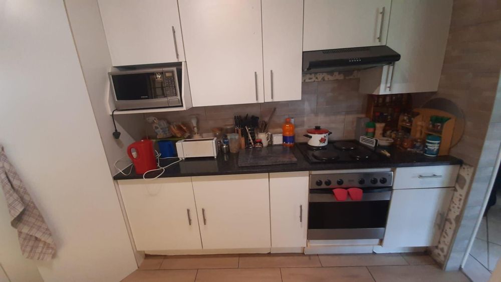 Kitchen with sufficient work and cupboard space and 4 plate stove, oven and extractor fan