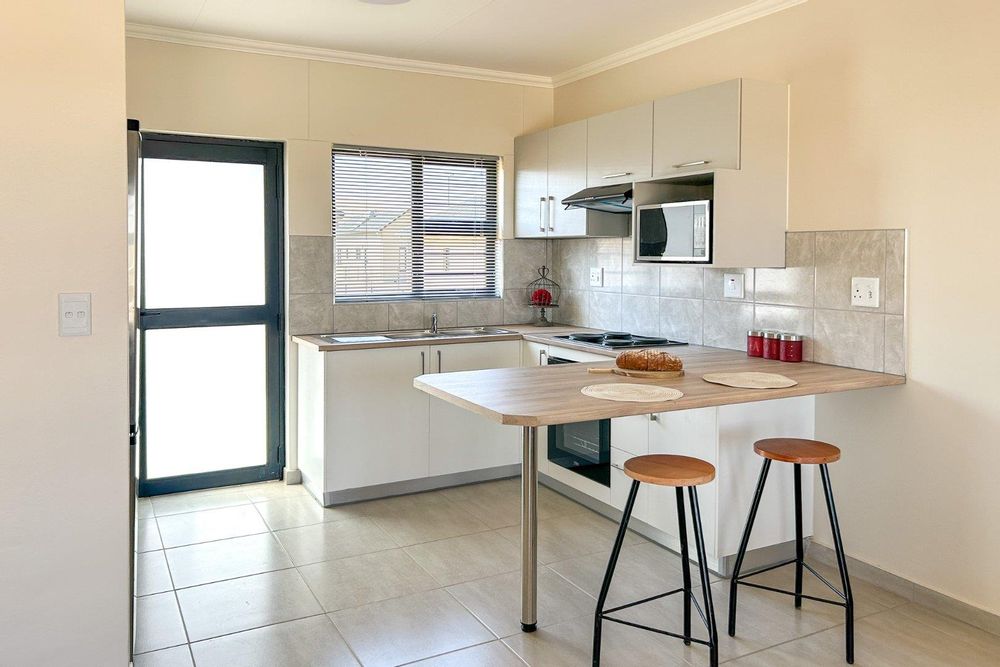 Kitchen with built-in cupboards + oven and sit-down countertop.