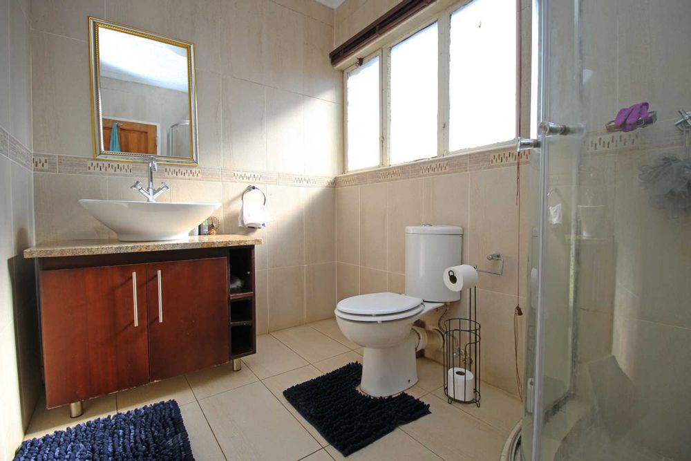 Bathroom 2 : Family Bathroom with Clearview Corner Shower, Modern Vanity with Countertop Basin on a Caramel coloured Granite surface, adding a decorative and modern focal point to the bathroom 
