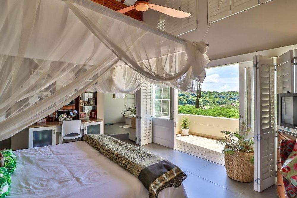 MAIN BEDROOM LEADING ONTO THE BALCONY WITH ESTATE AND FAIRWAY VIEWS
