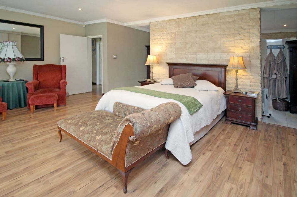 Spacious main bedroom with laminated floors and en-suite bathroom