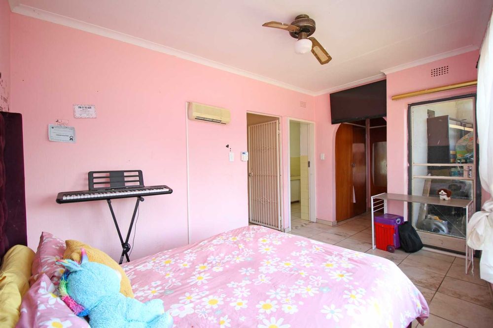 Bedroom 1 : Main Ensuite Bedroom with walk-in Dressing Room with His& Hers Built-In Cupboards and a Balcony that overlooks the expansive Garden Terrace, the Swimming Pool and the Entertainment Area