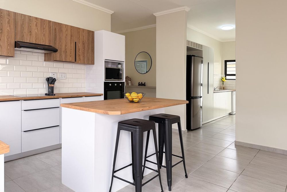 Large kitchen with white gloss cupboards and kitchen island.