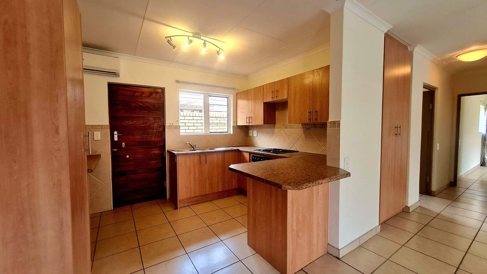 Open plan kitchen area, fully tiled and with air-conditioner with air flowing into the lounge area