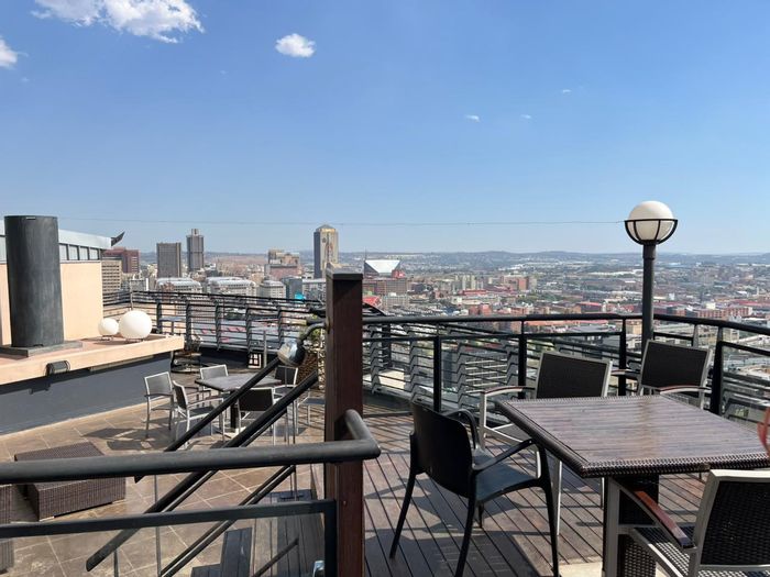 Braamfontein Apartment To Rent: Furnished 1-bedroom with balcony, secure amenities, and workspace.