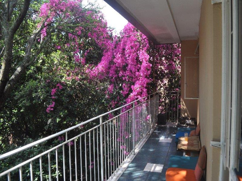 large balcony in front of living areas overlooking garden and pool