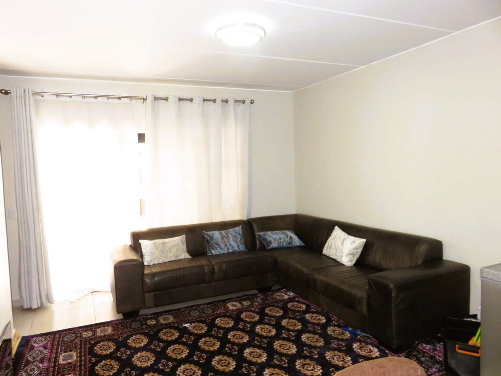 Lounge - spacious with sliding door leading to private court yard with covered patio and built-in braai. 