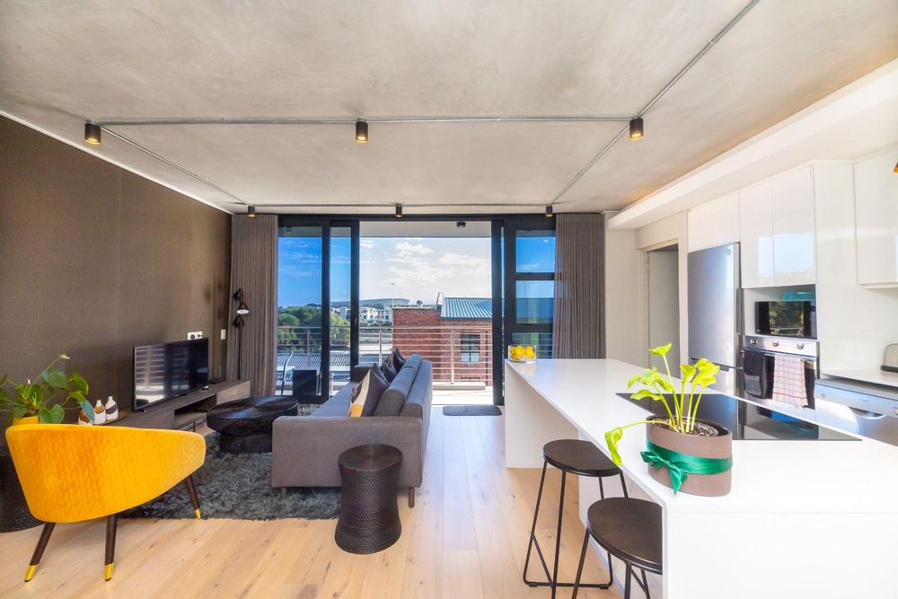 open plan living, dining and kitchen area opens unto balcony with views towards Greenpoint and Signal Hill