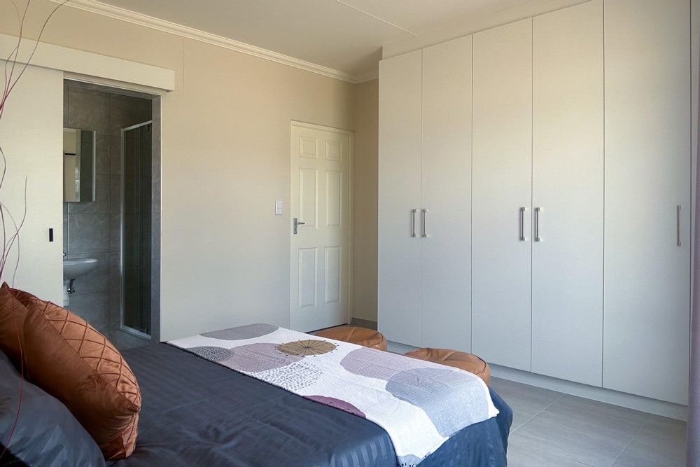 Spacious main bedroom with built-in cupboards and ensuite bathroom.