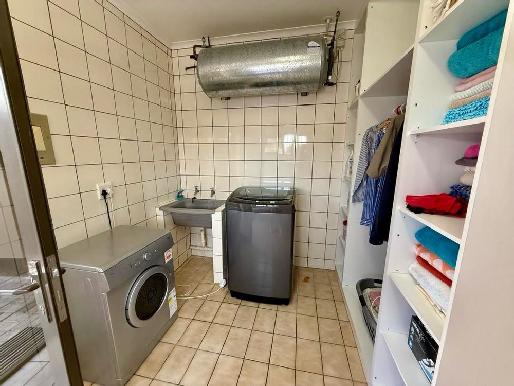 Laundry room behind walk-in closet