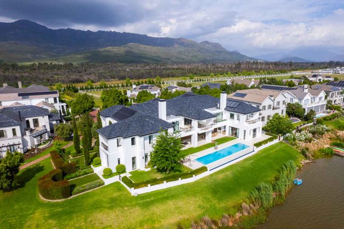 Lakefront house in Val De Vie Estate for sale, featuring infinity pool and solar panels.