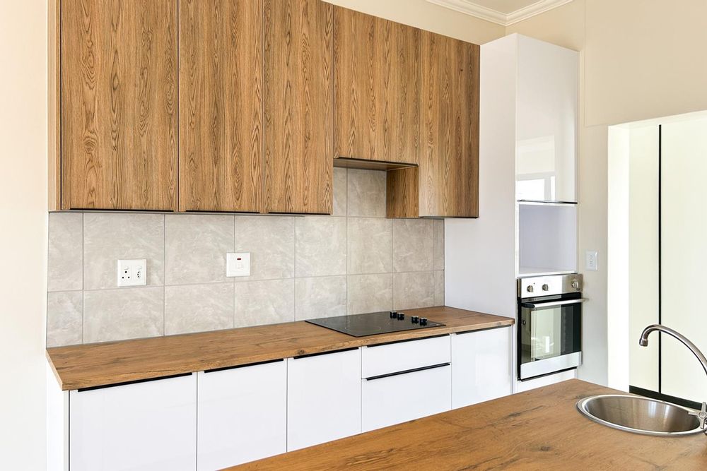 Modern, white gloss kitchen with scullery. Built-in stove and plenty of built-in cupboards.