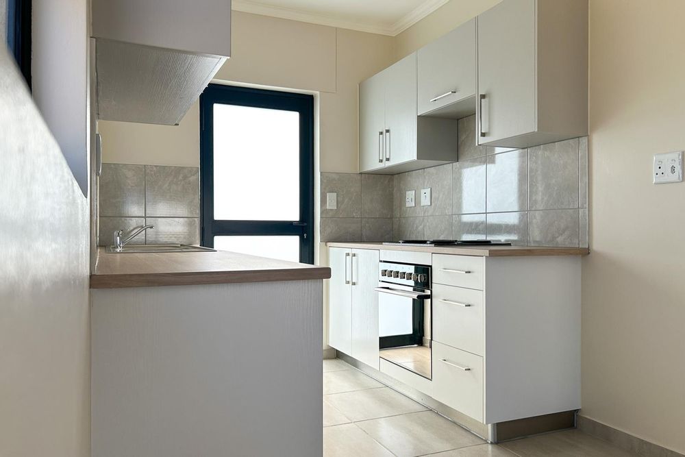 Kitchen with built-in cupboards & built-in oven.